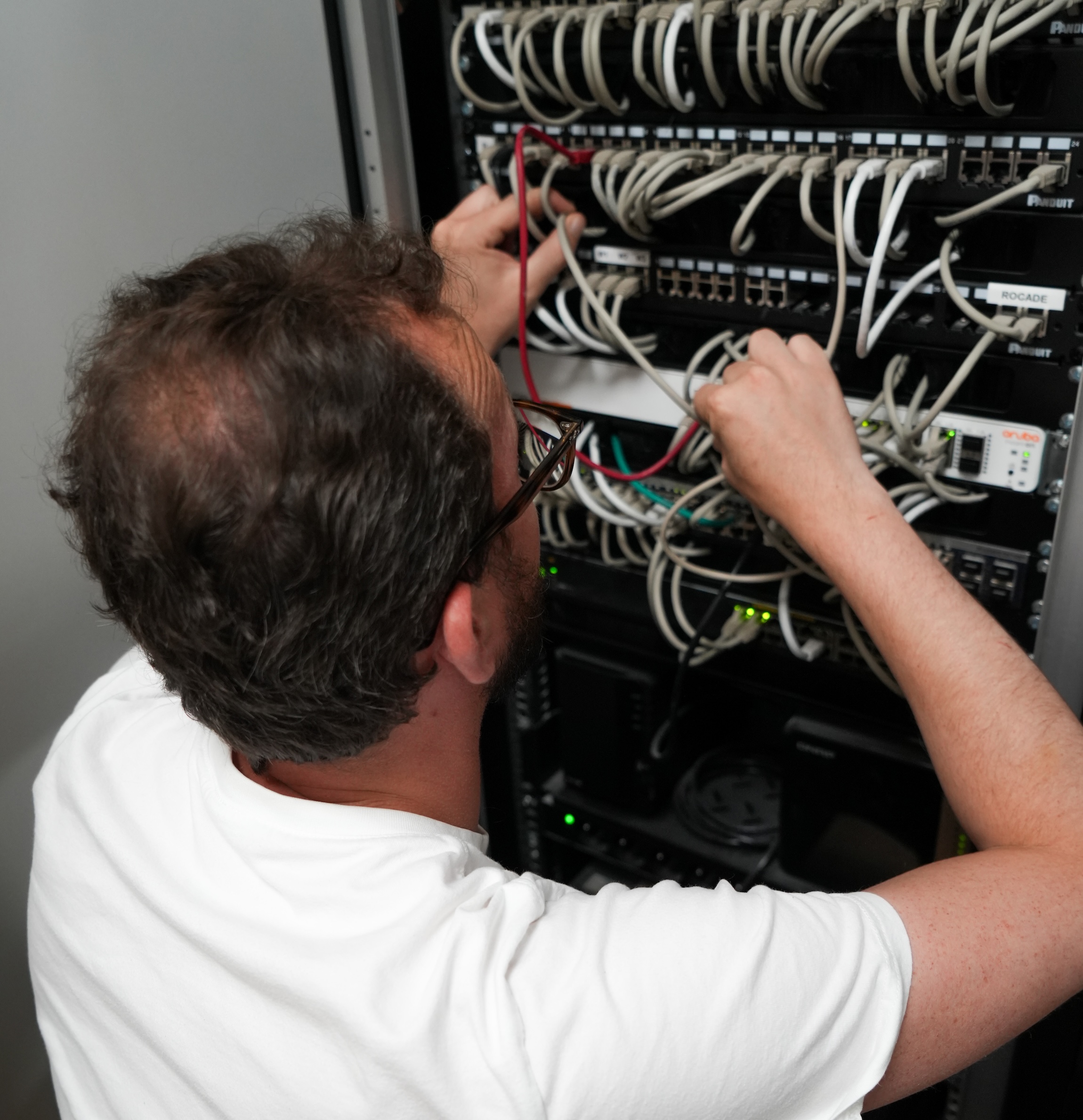 Ingénieur système et réseaux d’EBS Group installant un firewall dans une baie informatique en mode LAN, renforçant la sécurité réseau pour les entreprises avec une solution de protection avancée et optimisée.